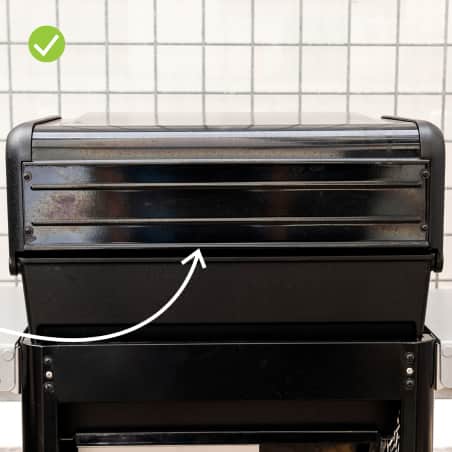 The back of a gas grill with a small rear vent.